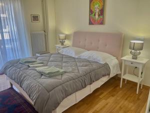 ein Schlafzimmer mit einem großen Bett mit zwei Nachttischen in der Unterkunft Athens Faliro Beach Residence in Athen