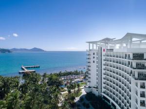 uitzicht op een gebouw en de oceaan bij Sanya Junji Seaview Hotel in Sanya