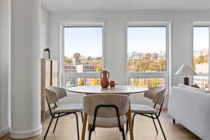 a dining room with a table and chairs and windows at Hoboken 2br w wd gym nr light rail NYC-946 in Hoboken