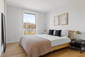 a white bedroom with a large bed and a window at Hoboken 2br w wd gym nr light rail NYC-946 in Hoboken