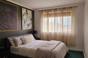 - une chambre avec un grand lit et une fenêtre dans l'établissement 2 Bed Apartment York Street Sale, à Sale