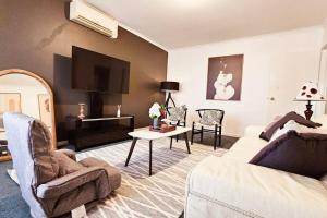 ein Wohnzimmer mit einem Sofa und einem TV in der Unterkunft 2 Bed Apartment York Street Sale in Sale