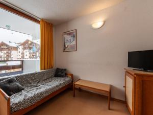 een woonkamer met een bank en een groot raam bij Les Eterlous 25 - Appt vue pistes 4 pers in Morillon