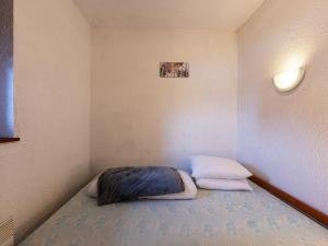 Habitación pequeña con 1 cama con 2 almohadas en Les Eterlous 25 - Appt vue pistes 4 pers en Morillon