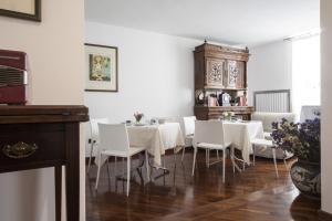 a dining room with white tables and white chairs at B&B Acquapazza in Brindisi