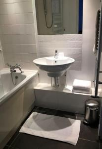 a bathroom with a sink and a bath tub at Victoria Park 1 bedroom flat in London
