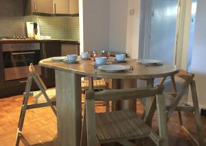 a wooden table and chairs in a kitchen at Victoria Park 1 bedroom flat in London
