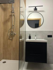 a bathroom with a sink and a mirror at Apartament Black in Pasłęk +6 photos
