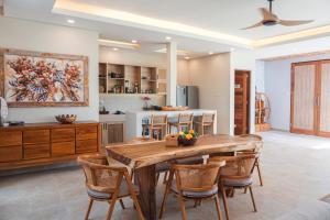 cocina y comedor con mesa de madera y sillas en Villa 10 Rose Bali 3BR Luxury en Ungasan