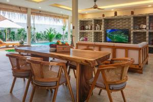 comedor con mesa de madera y sillas en Villa 10 Rose Bali 3BR Luxury en Ungasan