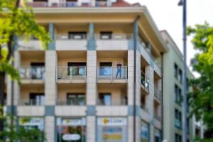 a person standing on a balcony of a building at Apartament Rondo VERONA - Darmowy parking dla Gości in Wrocław