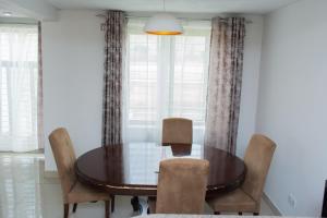 - une salle à manger avec une table et des chaises en bois dans l'établissement Divine Heights Apartments Lilongwe Area 43, à Lilongwe