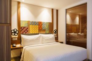 a bedroom with a large white bed and a window at Fairfield by Marriott Bali South Kuta in Kuta