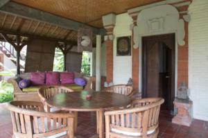 un patio con tavolo, sedie e un divano di Abalone Sport Resort a Manggis