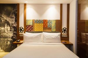 a bedroom with a bed and a painting on the wall at Fairfield by Marriott Bali South Kuta in Kuta