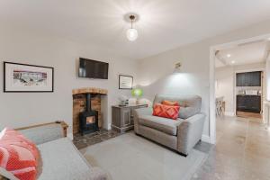 a living room with a couch and a fireplace at 3 Mill Street - Norfolk Cottage Agency in Holt