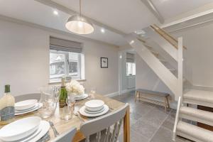 a dining room with a table and a staircase at 3 Mill Street - Norfolk Cottage Agency in Holt