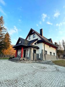 a large white house with a black roof at HELLO GIEWONT in Zakopane