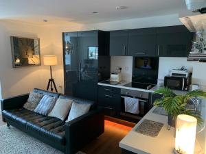 een woonkamer met een bank en een keuken bij Stunning two bed city Center apartment in Liverpool