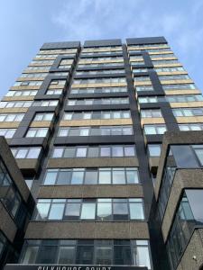 een hoog kantoorgebouw met glazen ramen bij Stunning two bed city Center apartment in Liverpool