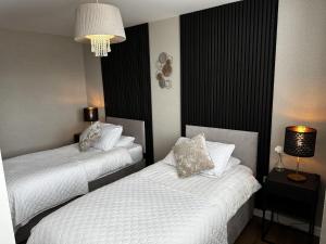 a hotel room with two beds and a chandelier at Stunning two bed city Center apartment in Liverpool