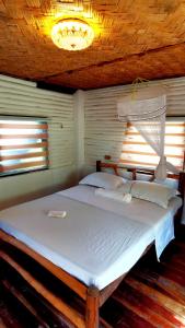 a large bed in a room with two windows at Dreamer Resort in San Vicente