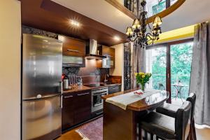 a kitchen with a stainless steel refrigerator and a table at Apartament Rondo VERONA - Darmowy parking dla Gości in Wrocław