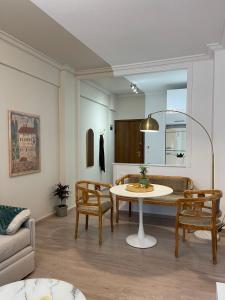 - un salon avec une table, des chaises et un canapé dans l'établissement Syntagma Hideaway Luxury Apt, à Athènes
