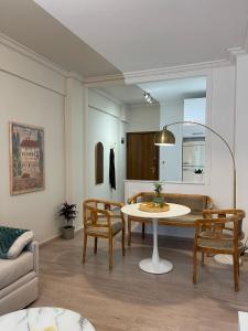 a living room with a table and chairs and a couch at Syntagma Hideaway Luxury Apt in Athens