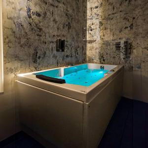 a bath tub with blue water in a room at The Bunksters Bir in Bīr