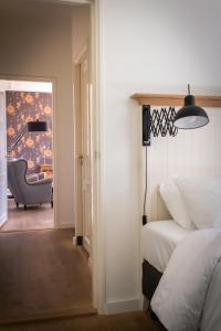 1 dormitorio con 1 cama y 1 silla en una habitación en Het Weeshuis, en Bolsward