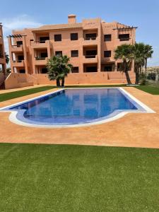 a large swimming pool in front of a building at Sunbird Los Alcázares Golf in Los Alcázares