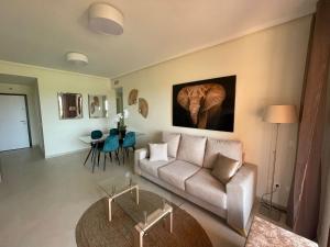 - un salon avec un canapé et une peinture d'éléphant sur le mur dans l'établissement Sunbird Los Alcázares Golf, à Los Alcázares