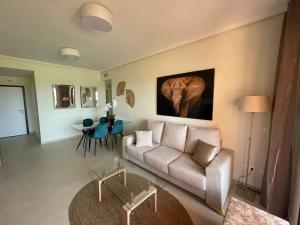 a living room with a couch and an elephant painting on the wall at Sunbird Los Alcázares Golf in Los Alcázares