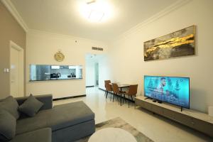 a living room with a couch and a flat screen tv at One Bedroom Apartment at MAG214 JLT by ANW Vacation Homes in Dubai