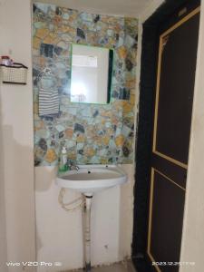 łazienka z umywalką i lustrem na ścianie w obiekcie Matoshree Nivas w mieście Lohogaon
