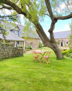 a picnic table under a tree in a yard at Gîte du Triskell Le Domaine de Coat Rogan in Pommerit-Jaudy +12 photos