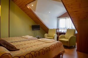 a bedroom with a large bed and two chairs at Casa Rural Portal de Numancia ll in Garray