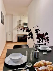 a black table with plates of food on it at urbanstays Linz Denkstraße in Linz