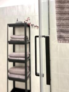 a towel rack with purple towels and a mirror at urbanstays Linz Denkstraße in Linz