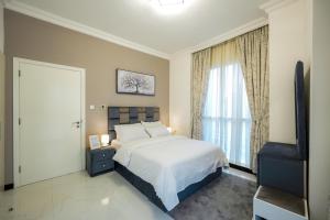 a bedroom with a bed and a large window at One Bedroom Apartment at MAG214 JLT by ANW Vacation Homes in Dubai