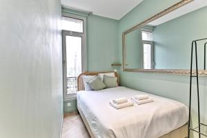 - une chambre avec un lit et 2 serviettes dans l'établissement Appartement proche Parc Monceau - II, à Paris
