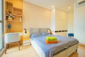 ein kleines Schlafzimmer mit einem Bett und einem Stuhl in der Unterkunft Casa Par Grand Suites - Millennium Masteri, High-class and Central Location in Ho-Chi-Minh-Stadt