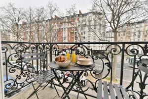 une table avec deux bols de nourriture sur un balcon dans l'établissement Appartement proche Parc Monceau - II, à Paris