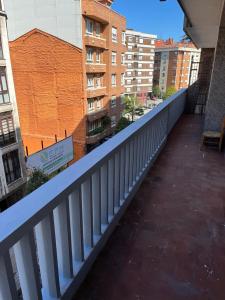 Un balcón con barandilla blanca en una ciudad. en Amplio apartamento en La Arena, 4 hab, en Gijón