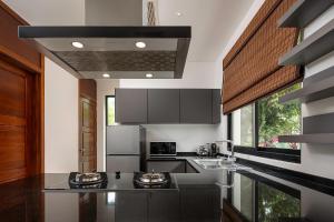 cocina con encimeras negras y ventana grande en Villa Decor en Mae Nam Beach