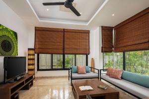 a living room with a couch and a tv at Villa Decor in Mae Nam