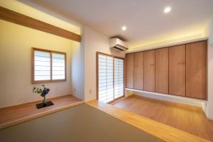 a large room with wooden cabinets and a window at 『花の影』カップル、ご友人、ご家族利用完全貸切!広々テラス露天風呂付!ポーラ美術館徒歩5分 in Hakone