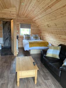 a log cabin with two beds and a couch at Pond View Pod 2 with Private Hot Tub -Pet Friendly- Fife - Loch Leven - Lomond Hills in Kelty