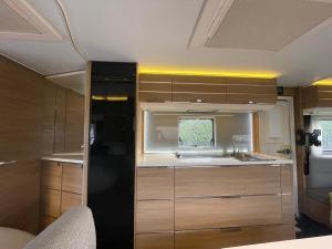 a kitchen with wooden cabinets and a black refrigerator at loond° Caravan Glamping 